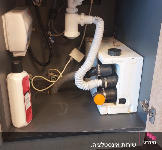 צנרת מתחת לכיור עם מחברים וצינורות פלסטיק